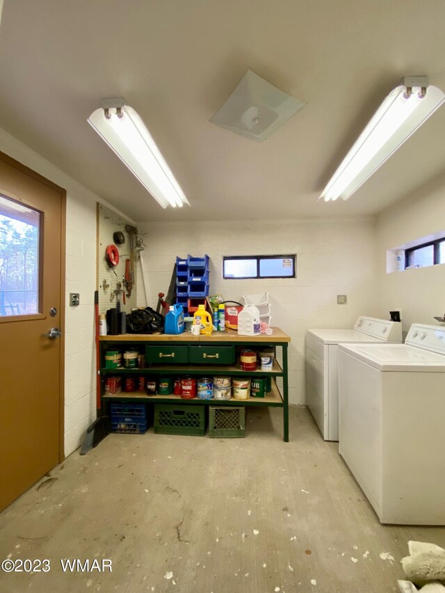 washroom featuring laundry area, washer and clothes dryer, and concrete block wall