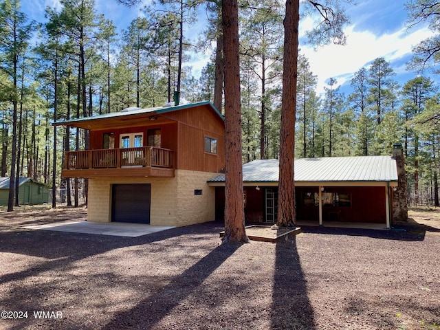 chalet / cabin featuring metal roof, a balcony, and dirt driveway