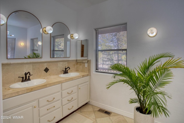 bathroom with tasteful backsplash, visible vents, and a sink