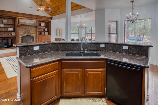 kitchen with a fireplace, a sink, black dishwasher, open floor plan, and brown cabinetry