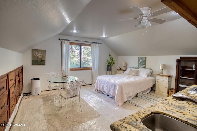 bedroom featuring lofted ceiling, a sink, and a textured ceiling