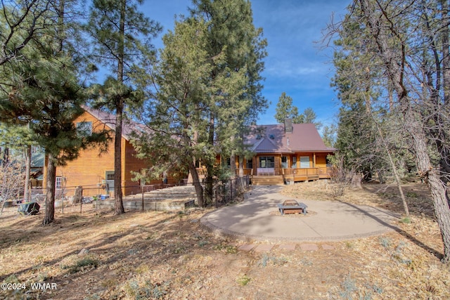 view of front of home with an outdoor fire pit and fence