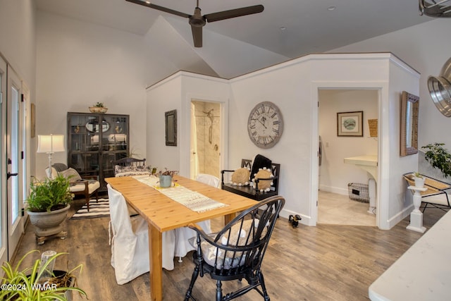 dining space featuring lofted ceiling, wood finished floors, a ceiling fan, and baseboards