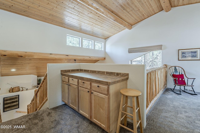 4509 Stone Pine Dr, Pinetop, AZ 85935 - kitchen featuring dark colored carpet, wooden ceiling with exposed beams, high vaulted ceiling, tile counters, and a kitchen bar