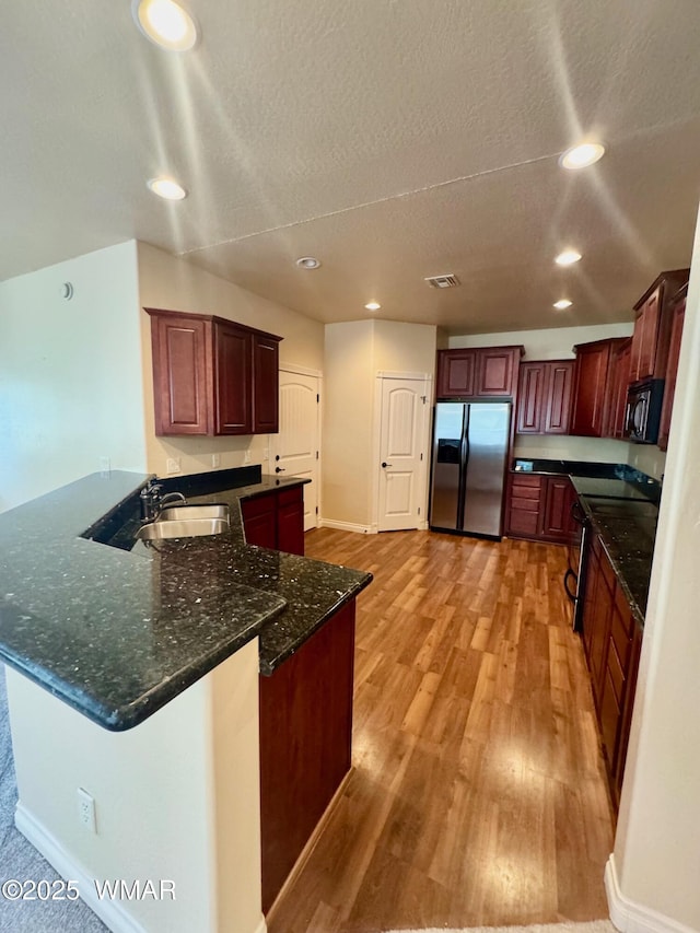 5200 S Morgan Mountain Dr, Show Low, AZ 85901 - kitchen featuring stainless steel fridge, black microwave, a peninsula, recessed lighting, and light wood-style floors