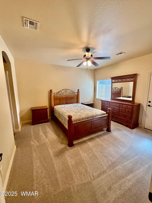 5200 S Morgan Mountain Dr, Show Low, AZ 85901 - bedroom with light carpet, a textured ceiling, arched walkways, and a ceiling fan