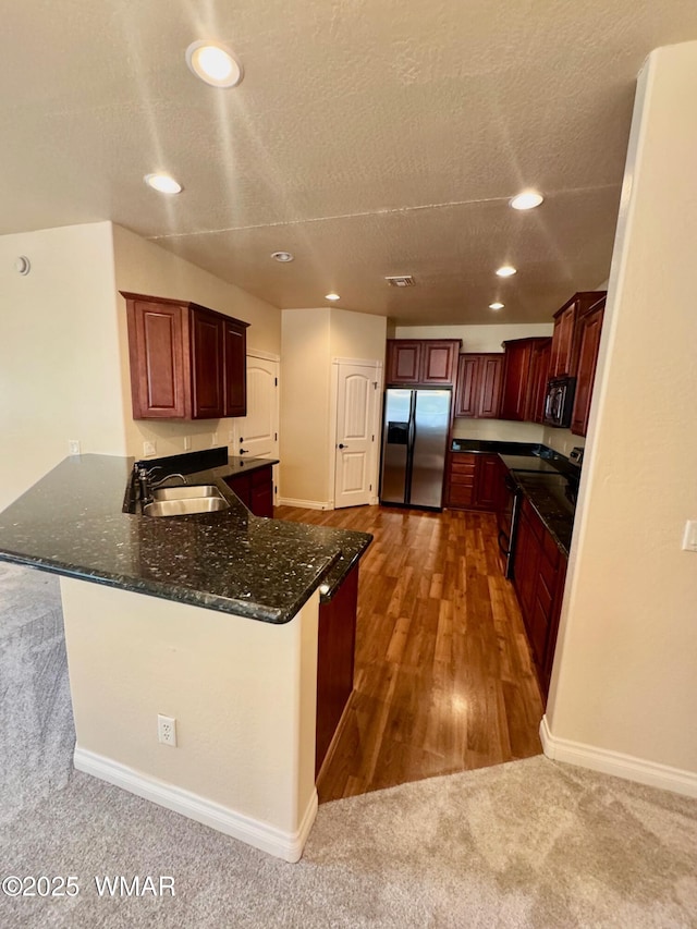 5200 S Morgan Mountain Dr, Show Low, AZ 85901 - kitchen featuring stainless steel fridge with ice dispenser, a peninsula, recessed lighting, dark stone countertops, and dark colored carpet