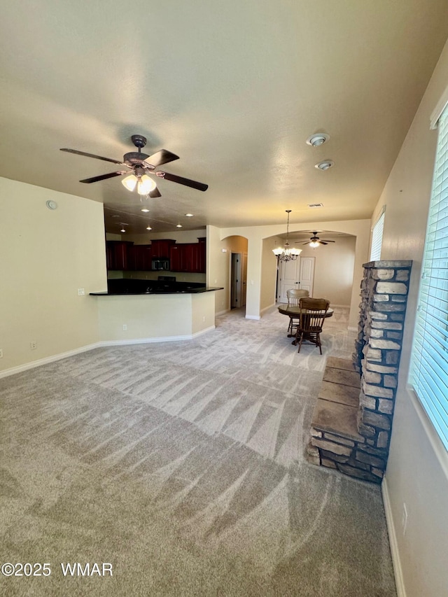 5200 S Morgan Mountain Dr, Show Low, AZ 85901 - unfurnished living room with a ceiling fan, arched walkways, a chandelier, and light carpet