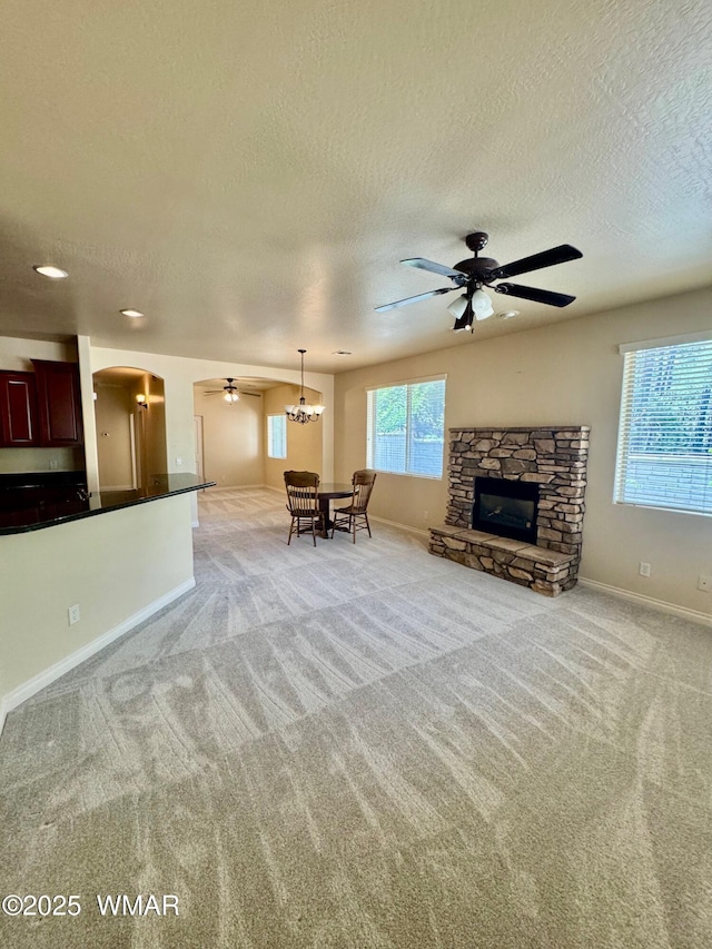 5200 S Morgan Mountain Dr, Show Low, AZ 85901 - living room with ceiling fan, a textured ceiling, arched walkways, light colored carpet, and a fireplace