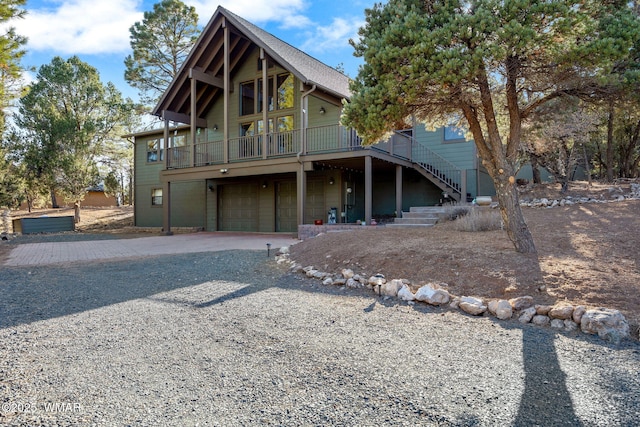 view of front of home with stairs, gravel driveway, and a garage