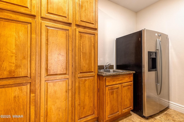 416 S 2nd St, Snowflake, AZ 85937 - kitchen featuring stainless steel fridge, a sink, brown cabinetry, dark countertops, and baseboards