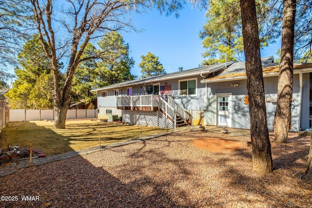 view of front of home featuring a deck, stairway, and a fenced backyard