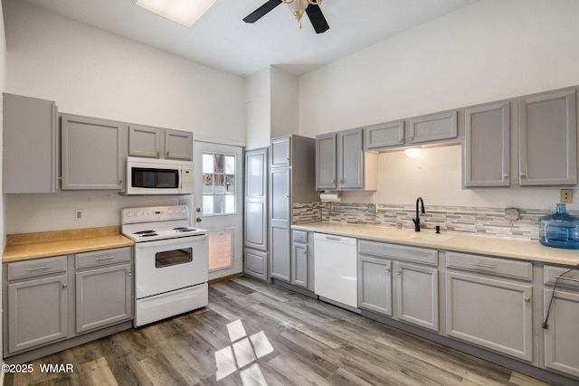 kitchen featuring light countertops, white appliances, and a sink