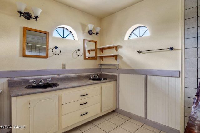 full bathroom featuring double vanity, a sink, and tile patterned floors