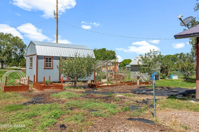 view of yard with a vegetable garden, an outdoor structure, and fence