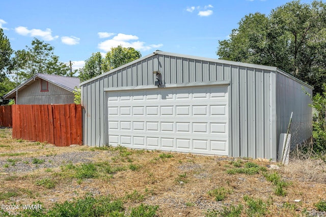 detached garage featuring fence