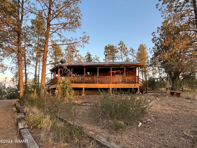 back of property featuring metal roof and a wooden deck