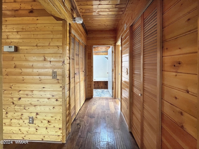 hallway with wood ceiling, wooden walls, and dark wood-style flooring