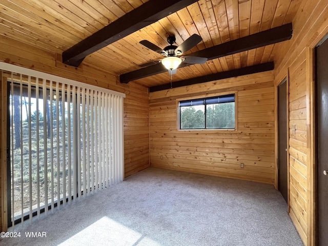 interior space featuring a ceiling fan, wooden ceiling, beam ceiling, and wooden walls