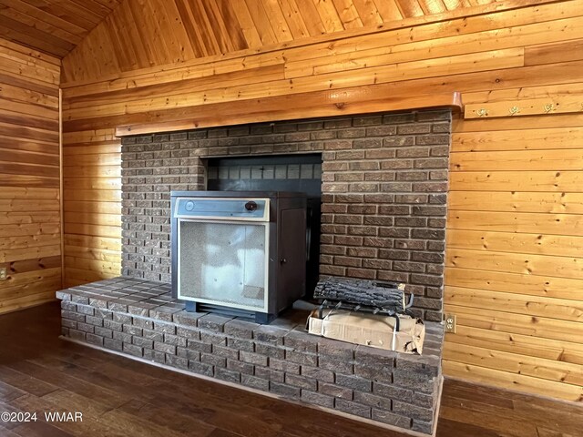 details with a wood stove, wood walls, and wood finished floors