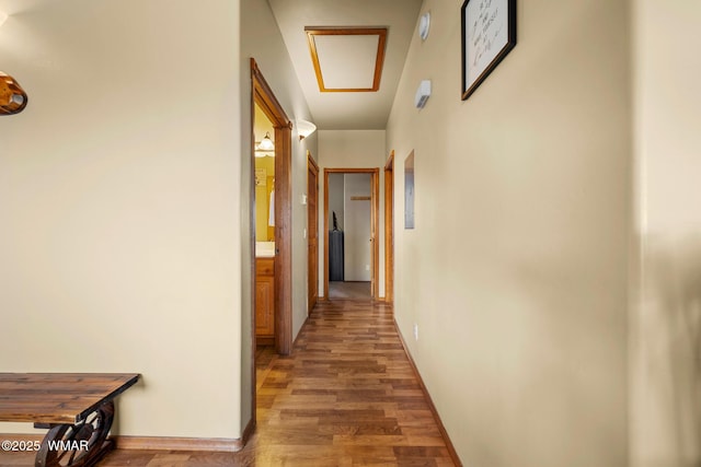 corridor featuring light wood finished floors and baseboards