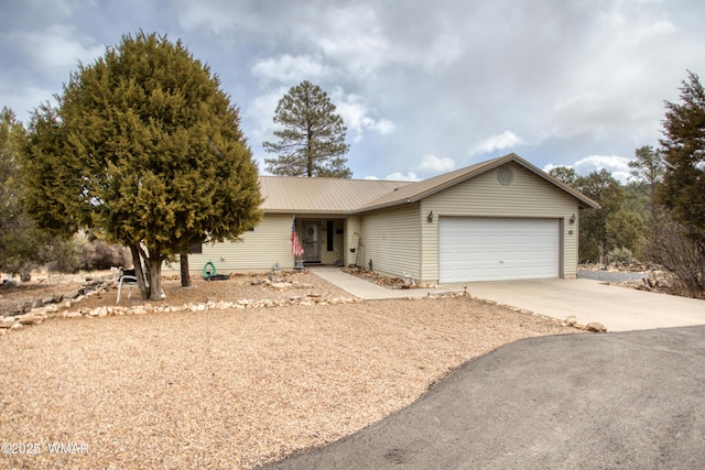 ranch-style home with an attached garage, driveway, and metal roof