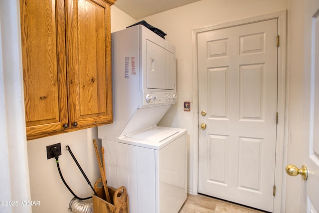 laundry area with stacked washing maching and dryer and cabinet space