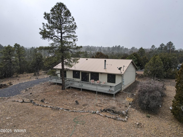 view of front of house with metal roof and a wooden deck