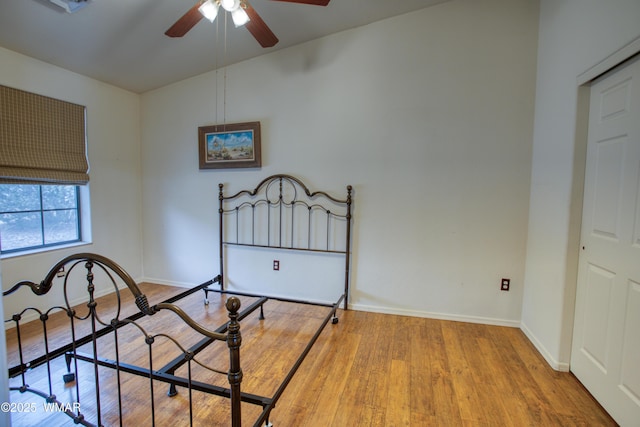 bedroom featuring a ceiling fan, baseboards, and wood finished floors