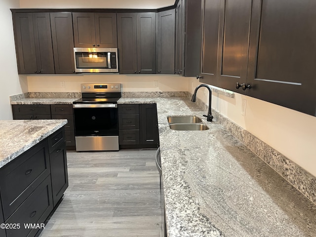 2490 Aspen Run, Pinetop, AZ 85935 - kitchen with light wood-style flooring, a sink, stainless steel appliances, and light stone counters