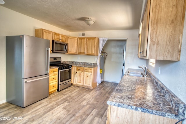 341 W 5th St S, Snowflake, AZ 85937 - kitchen featuring appliances with stainless steel finishes, light brown cabinets, light wood-type flooring, a sink, and a textured ceiling