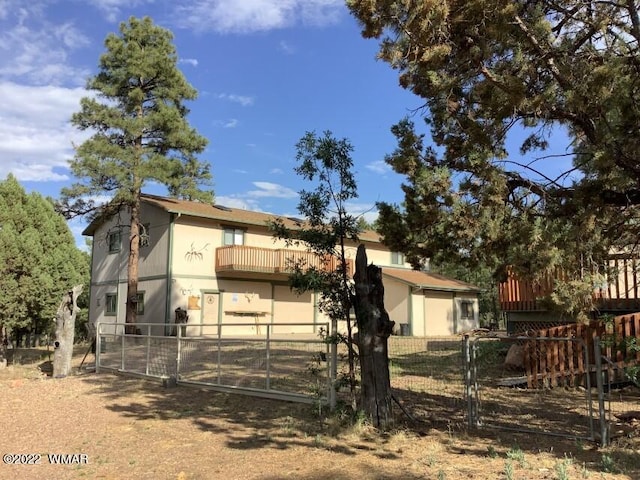 exterior space with a fenced front yard, a gate, and a balcony