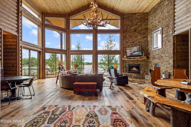 living area featuring a fireplace, a notable chandelier, wood ceiling, and a wealth of natural light