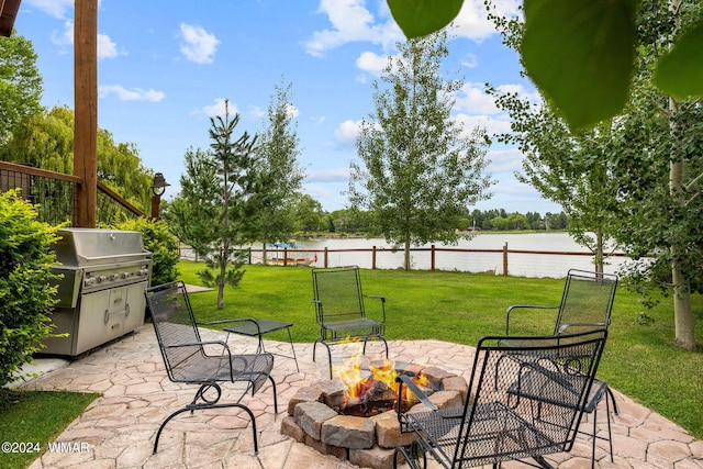 view of patio / terrace featuring an outdoor fire pit, fence, a water view, and a grill