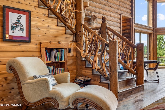 staircase with wood finished floors and rustic walls