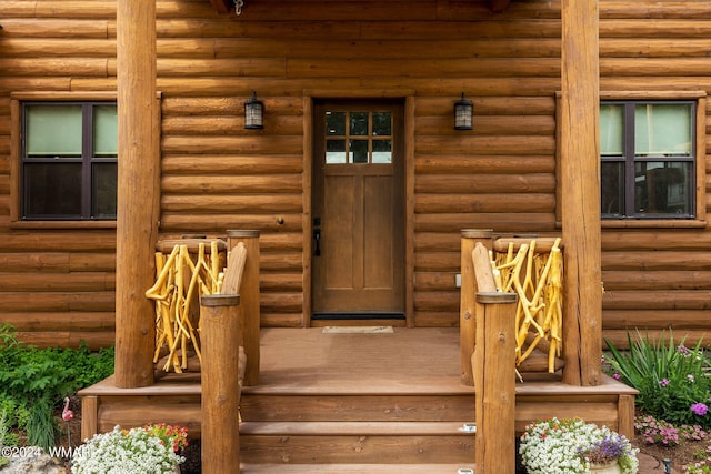 view of exterior entry with faux log siding