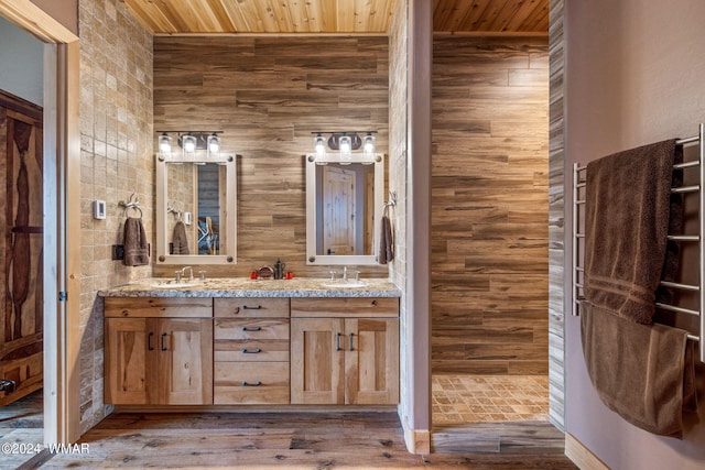 bathroom with double vanity, wood finished floors, wood ceiling, and a sink