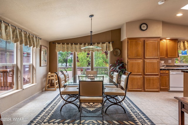 dining space with vaulted ceiling, light tile patterned flooring, and a textured ceiling