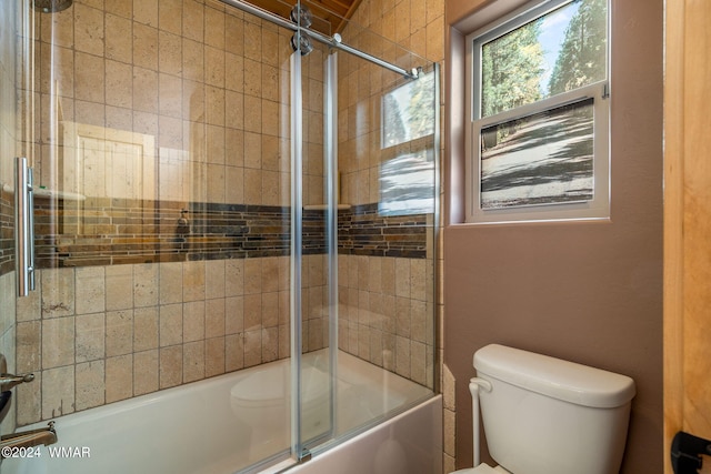 bathroom with shower / bath combination with glass door and toilet