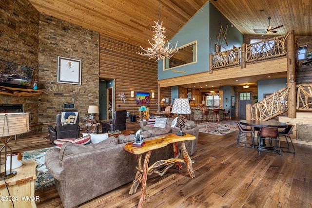 living area featuring stairway, a stone fireplace, wooden ceiling, an inviting chandelier, and wood-type flooring