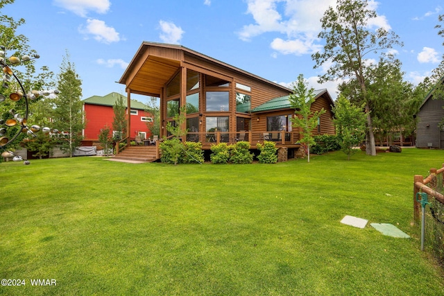 rear view of house featuring a deck and a yard