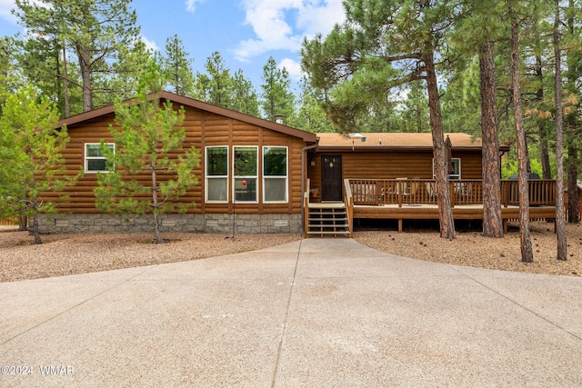 view of front of property with a deck and faux log siding