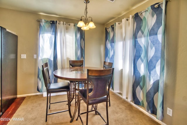 dining space featuring baseboards and an inviting chandelier