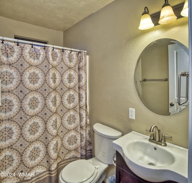 full bathroom with toilet, a textured wall, and vanity