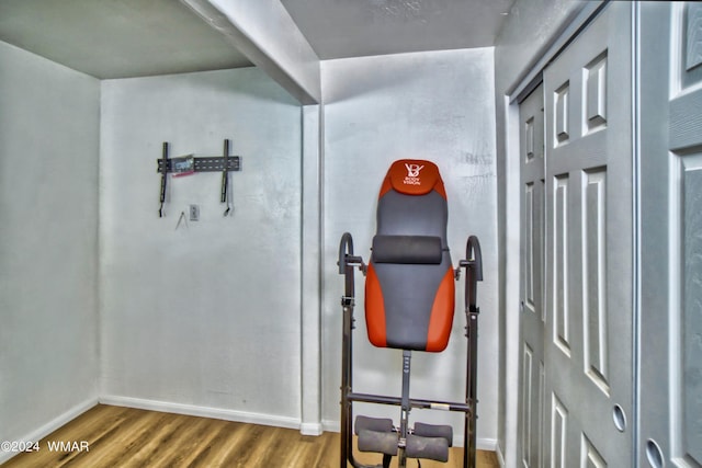 exercise room with wood finished floors and baseboards