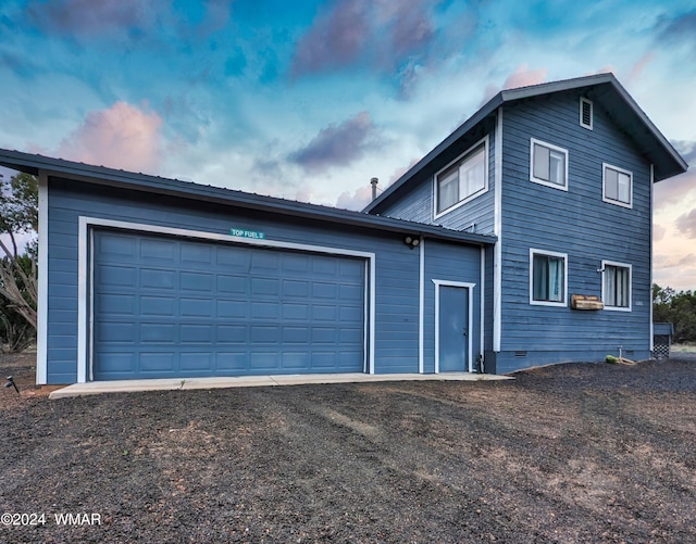 property exterior at dusk with metal roof and an attached garage