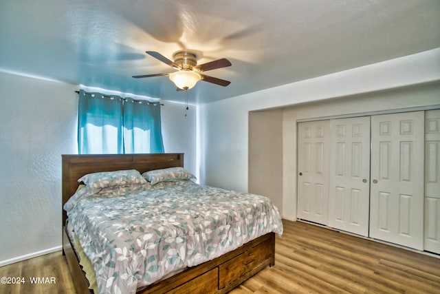 bedroom featuring wood finished floors, a ceiling fan, and a closet