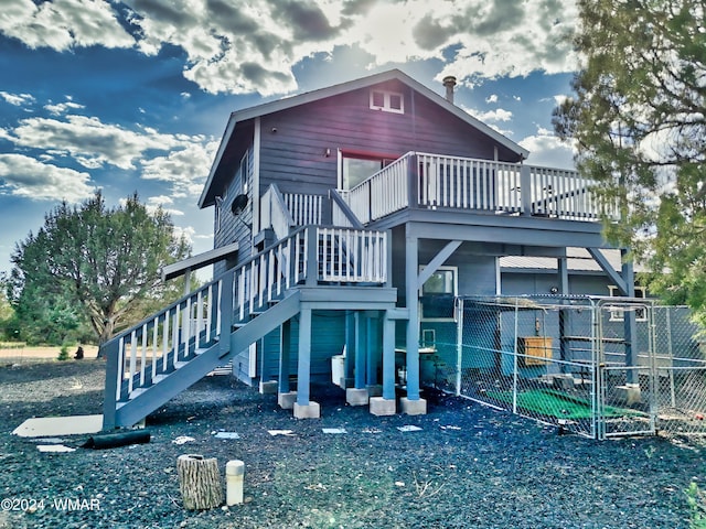 rear view of house featuring stairway and fence