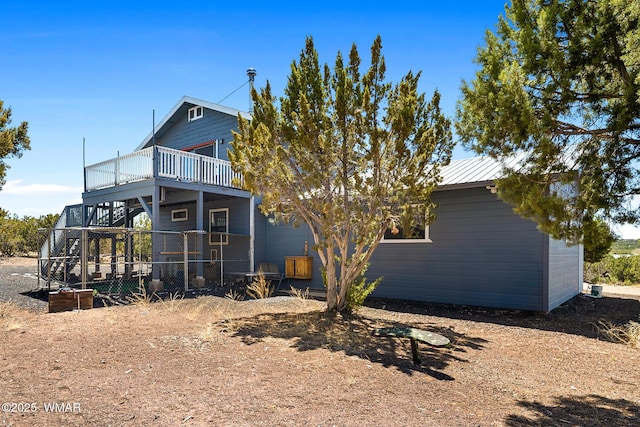 back of property featuring a wooden deck and metal roof