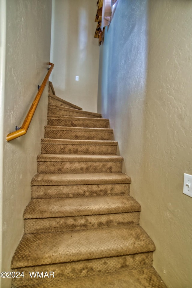stairway featuring a textured wall